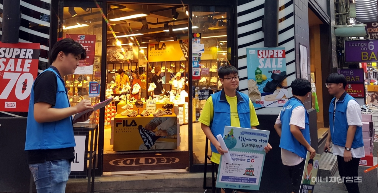 서울YWCA 청소년단이 명동거리에서 에너지절약 착한가게 캠페인을 알리는 활동을 하고 있다.
